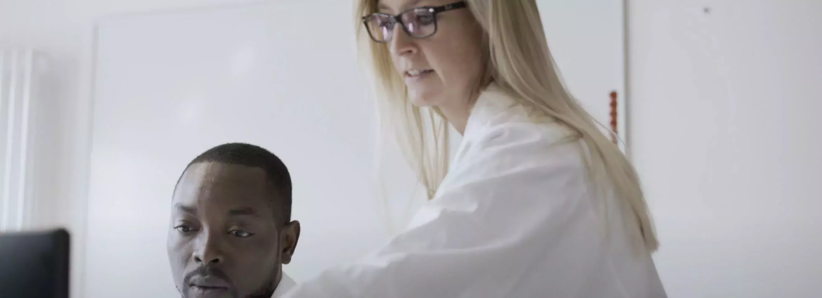 Eine Frau und ein Mann schauen gemeinsam auf einen Computerbildschirm