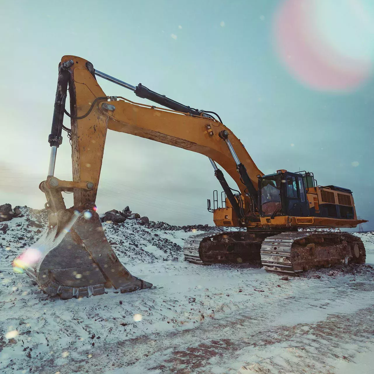 Orange excavator parked in the snow