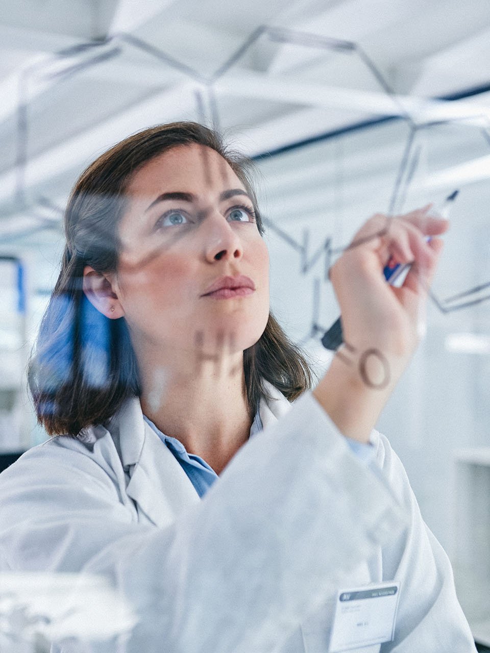 Femme dans un laboratoire qui écrit quelque chose sur un tableau